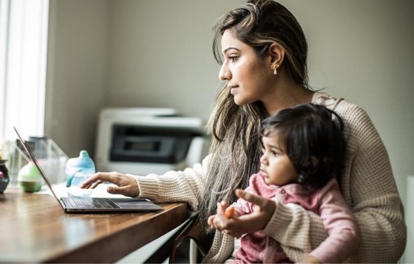 Woman on laptop with child on her lap