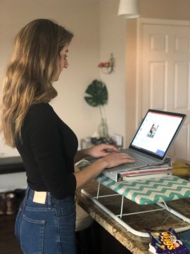 Woman working on laptop at standing desk