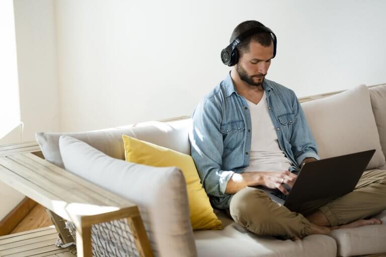 Man with laptop on sofa